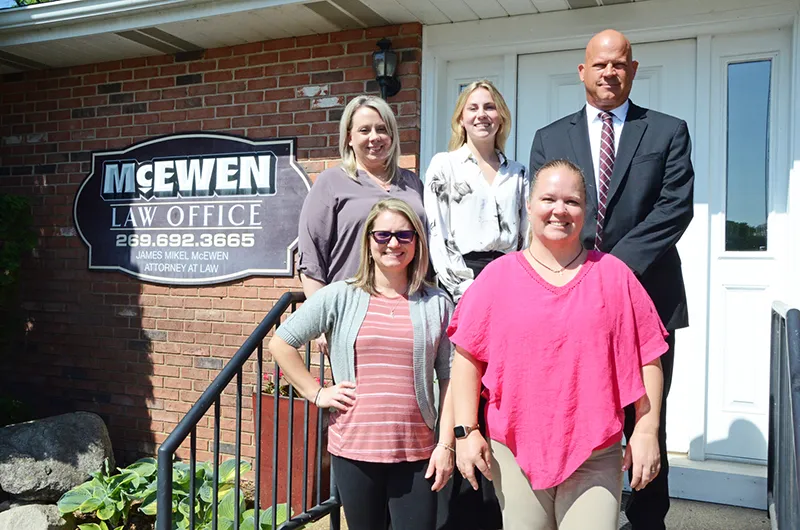 The McEwen Law Office team of lawyers and staff on the front steps of their office.